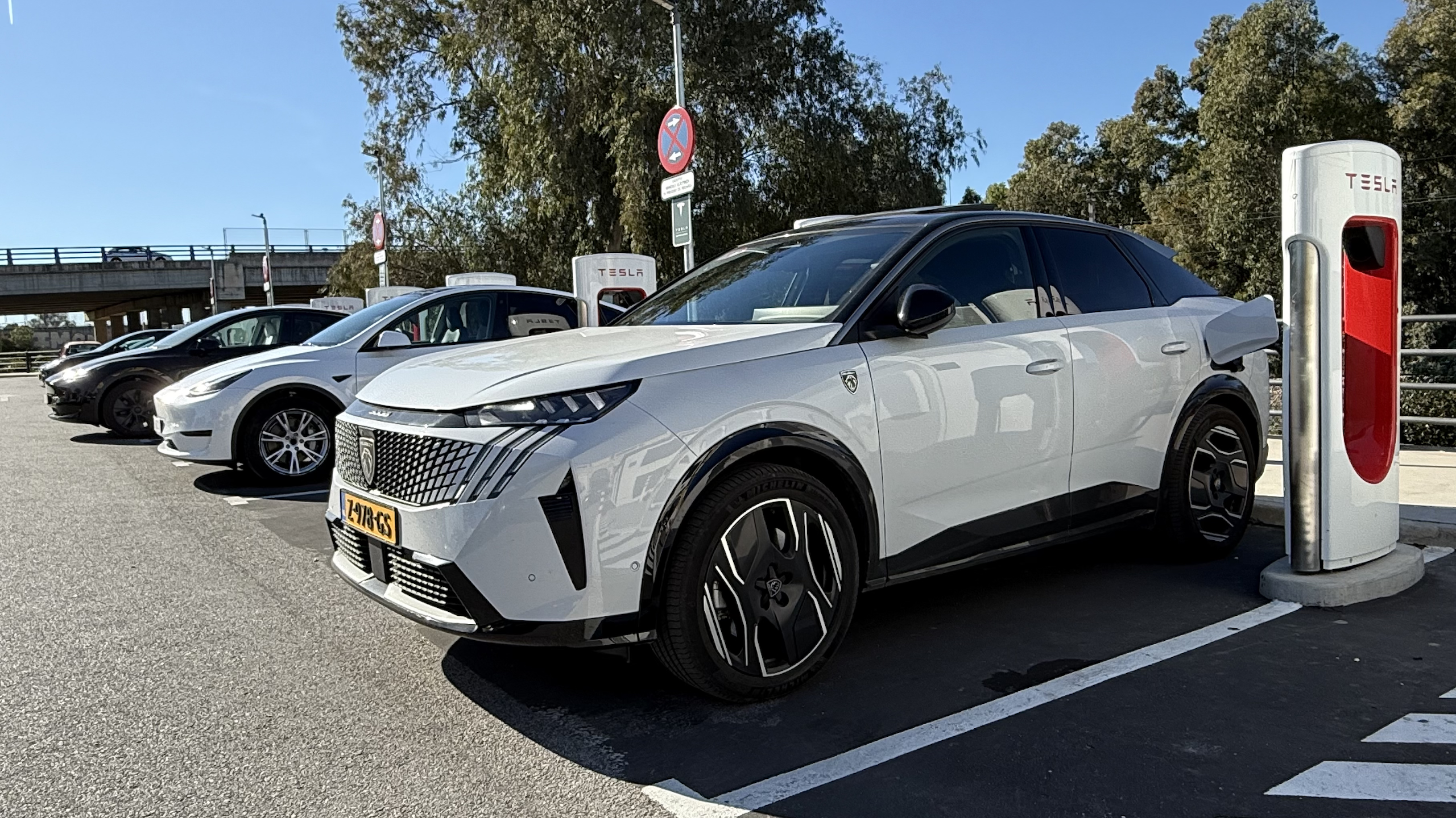 De e-3008 laden bij een Tesla supercharger station in Spanje